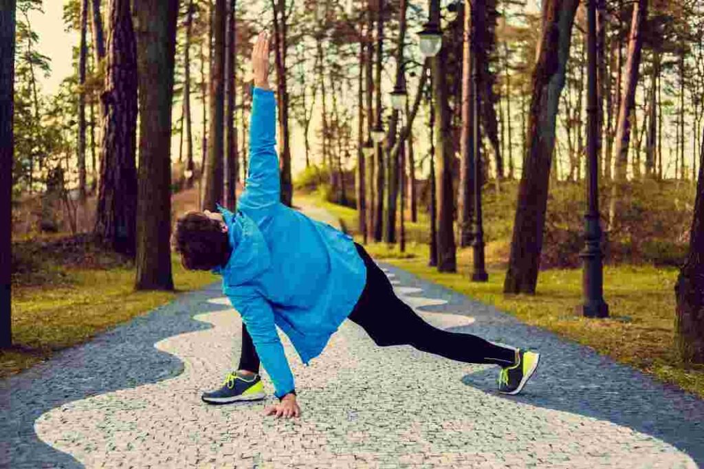 flexible-fitness-man-blue-sports-jacket-exercising-outside